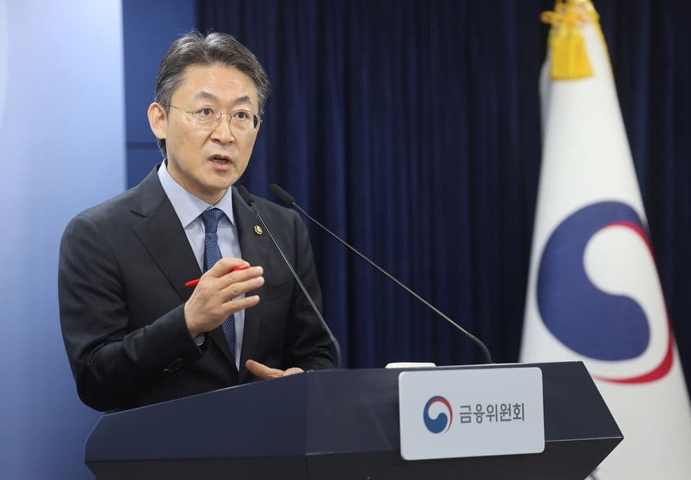 Một người đàn ông phát biểu tại bục, tượng trưng cho các phán quyết pháp lý và công nhận giá trị sáng tạo trong vụ kiện Min Hee-jin.