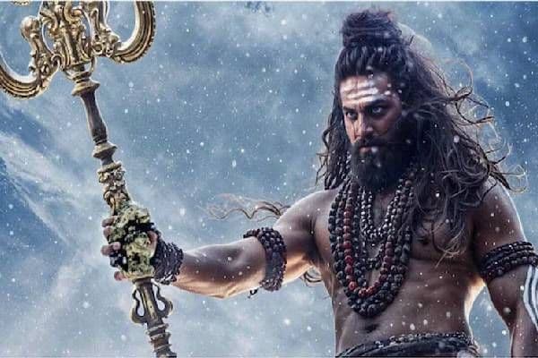 Một người đàn ông với mái tóc dài, râu rậm, cầm vũ khí, thể hiện hình ảnh nhân vật mạnh mẽ và chân thật.