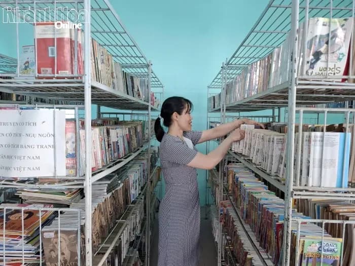 Một người phụ nữ sắp xếp sách trong thư viện, tượng trưng cho việc tận dụng kỳ nghỉ để học hỏi và phát triển bản thân.