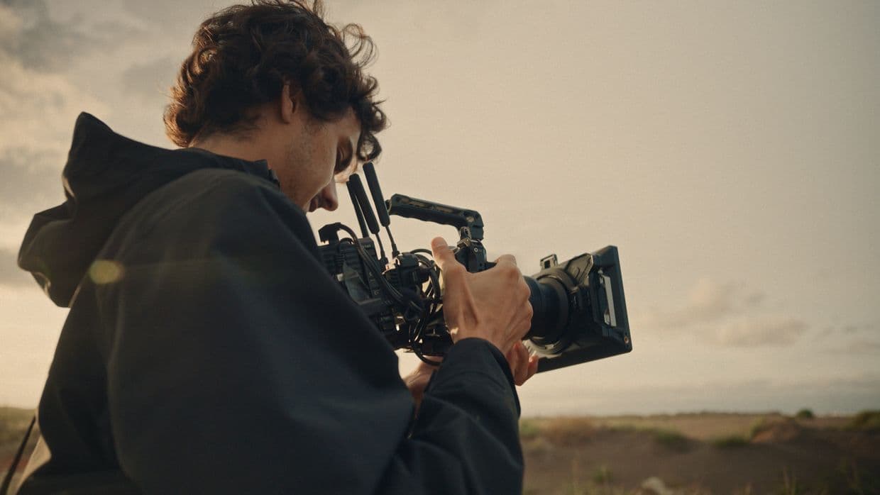 Một nhà làm phim sử dụng máy ảnh Nikon ZR để quay phim ngoài trời.