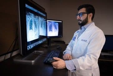 Một nhà nghiên cứu y tế xem xét dữ liệu X-quang, tượng trưng cho nghiên cứu về tuổi thọ ở California.