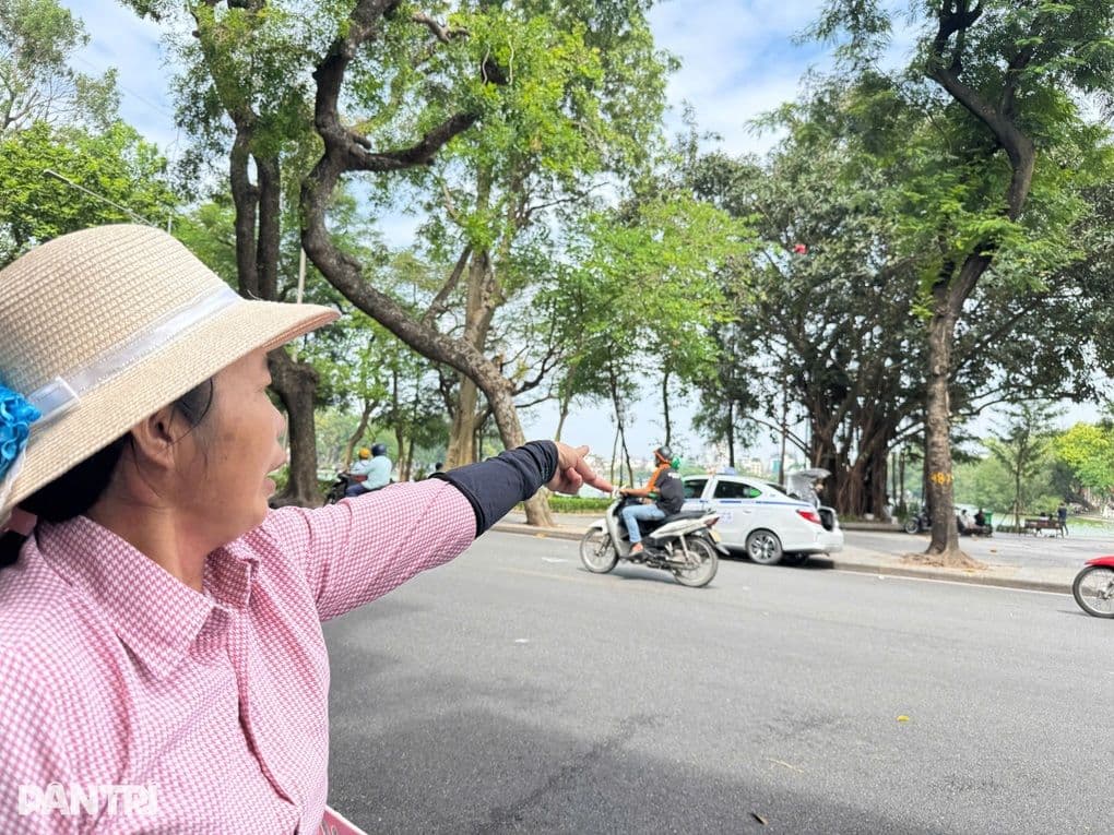 Một nhân chứng chỉ tay về phía Hồ Gươm, thể hiện sự bàng hoàng trước sự việc