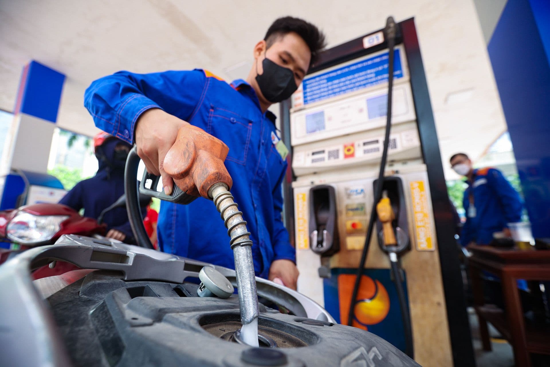 Một nhân viên đang đổ xăng E10 RON92 vào xe máy tại trạm xăng ở Việt Nam, minh họa tác động của giá dầu lên chi phí sinh hoạt.