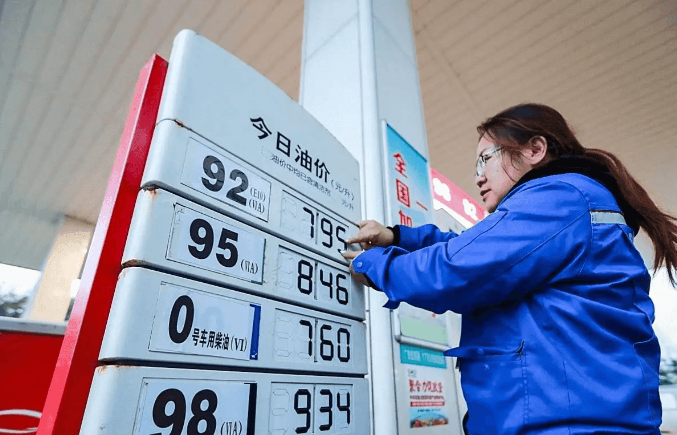 Một nhân viên điều chỉnh bảng giá xăng dầu tại trạm, thể hiện sự biến động và quản lý giá.