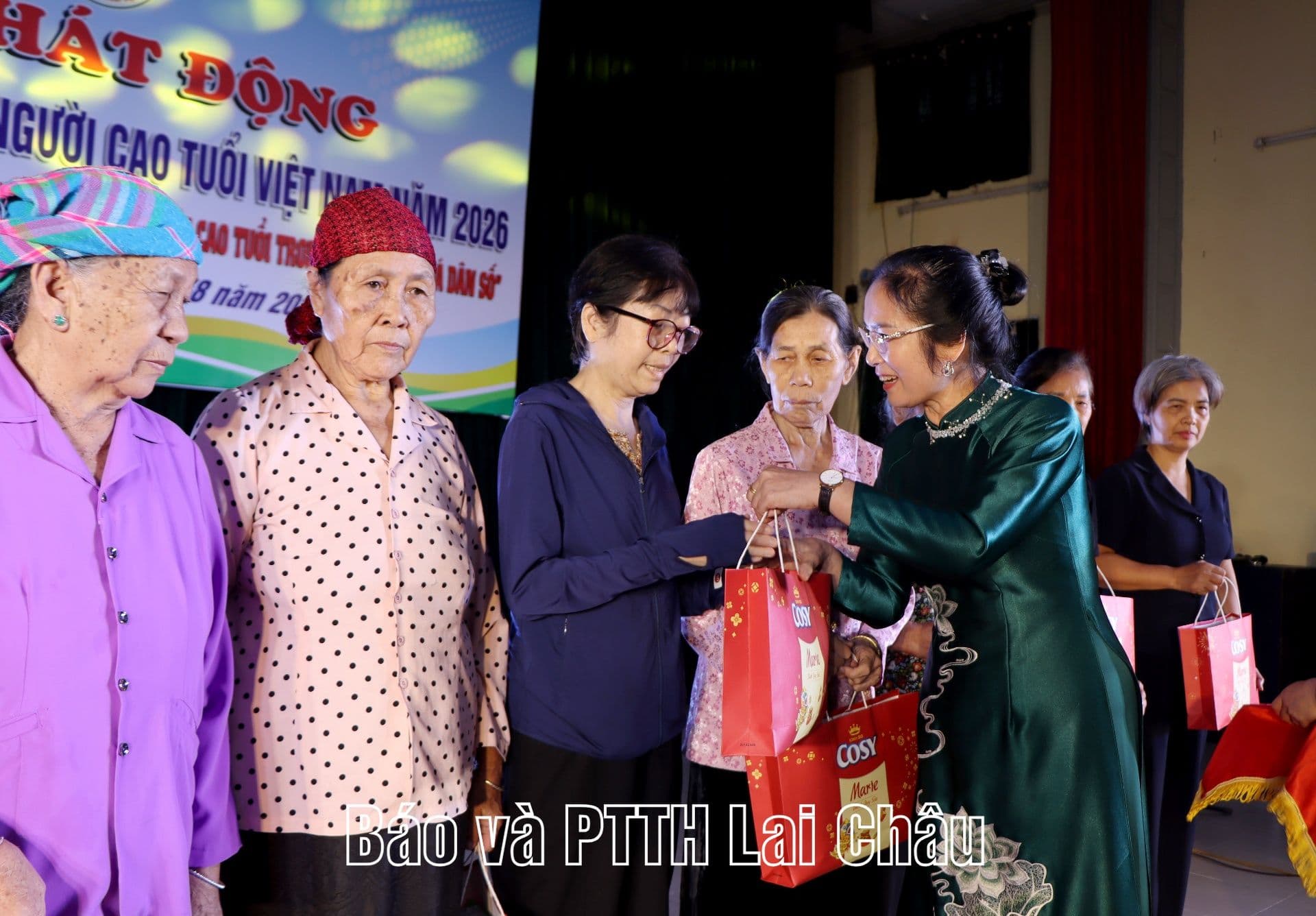 Một phụ nữ trao quà cho người cao tuổi, biểu tượng cho sự chăm sóc, hỗ trợ và tôn trọng thế hệ lớn tuổi trong nỗ lực xây dựng xã hội bao dung.