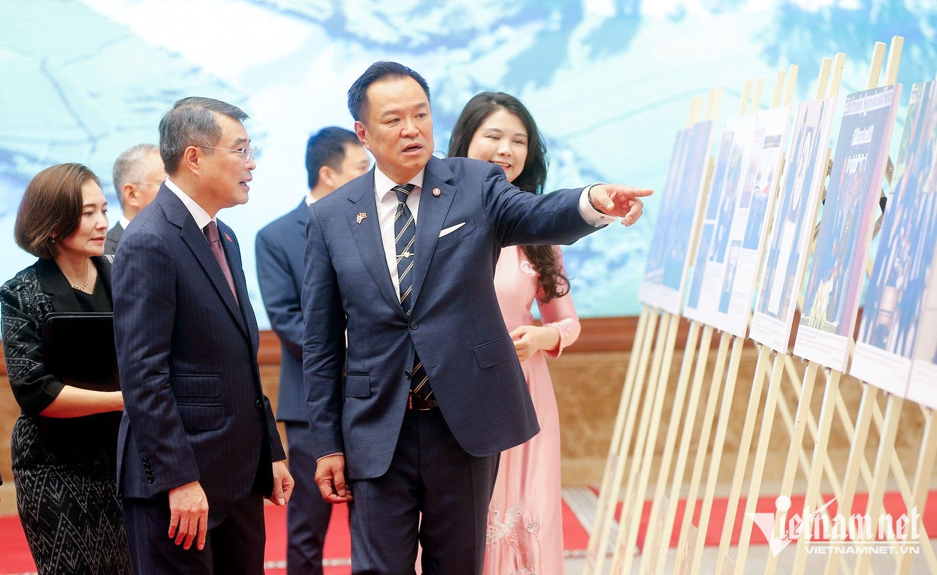 Một quan chức đang chỉ dẫn tại triển lãm, tượng trưng cho sự chủ động của Việt Nam trong việc định hình các xu hướng phát triển mới như chuyển đổi số và xanh.