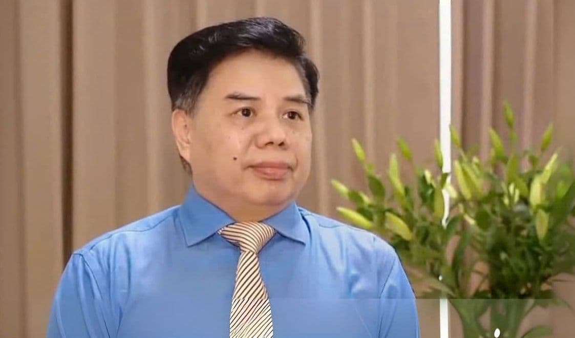 Một quan chức hoặc chuyên gia đang phát biểu, tượng trưng cho các cuộc thảo luận và chính sách để ổn định giá cả.