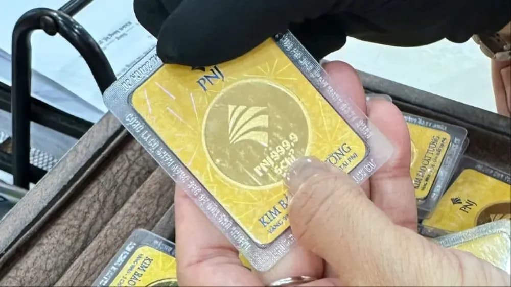 Một tay cầm miếng vàng PNJ, minh họa chính sách thanh toán 120 ngày của PNJ khi thu mua vàng và kim cương.