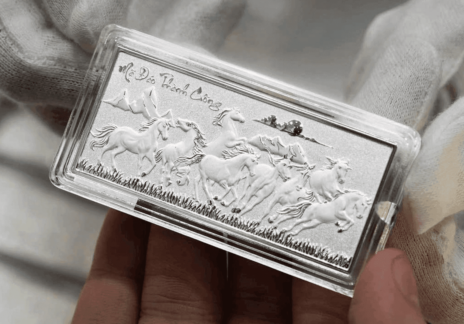 Một thỏi bạc trang trí hình ngựa 'Mã Đáo Thành Công' được giữ trong tay, thể hiện sự đa dạng của các sản phẩm bạc trên thị trường.