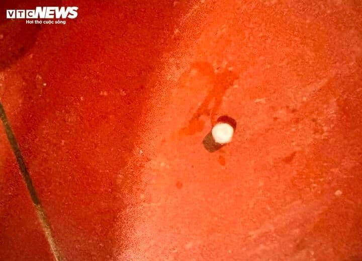 Một viên mưa đá lớn trên nền gạch đỏ, minh họa kích thước của những hạt mưa đá có thể rơi xuống, đặc biệt ở các khu vực đô thị.