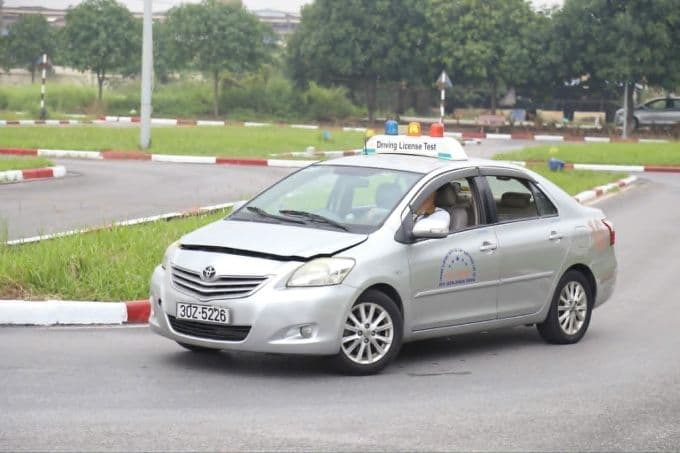 Một xe ô tô đang thực hiện bài sát hạch lái xe trên sân, minh họa cho những thay đổi trong quy trình thi bằng lái xe.