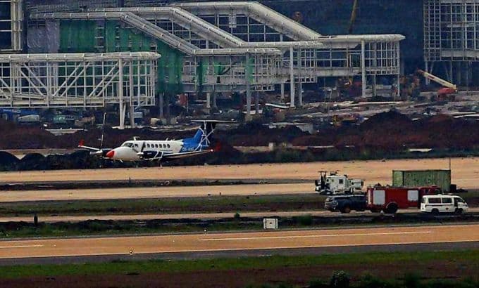 Máy bay hiệu chuẩn trên đường băng Sân bay Long Thành, phía sau là nhà ga hành khách đang hoàn thiện.