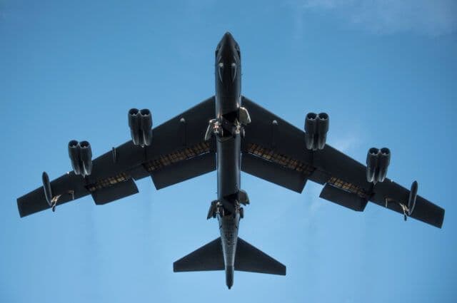 Máy bay ném bom B-52 Stratofortress nhìn từ dưới lên với càng hạ cánh độc đáo được triển khai, sẵn sàng cho 'vũ điệu cua'.