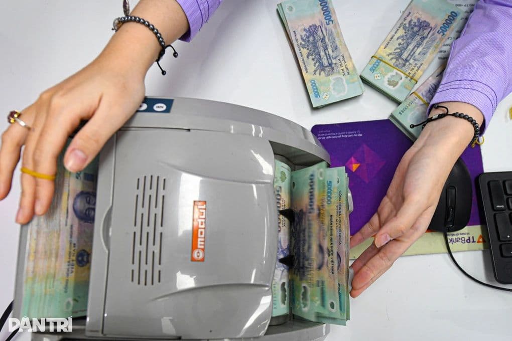 Máy đếm tiền và các cọc tiền 500.000 VND, tượng trưng cho việc quản lý chi trả lương theo quy định mới.