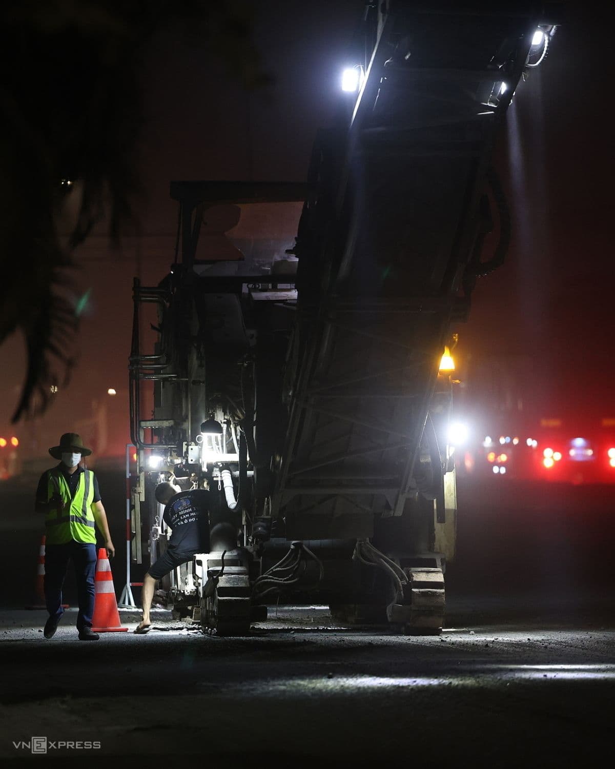 Máy móc thi công đường hoạt động vào ban đêm, tượng trưng cho nỗ lực '3 ca 4 kíp' nhằm đẩy nhanh tiến độ dự án Quốc lộ 51 và niềm tin vào tương lai phát triển.