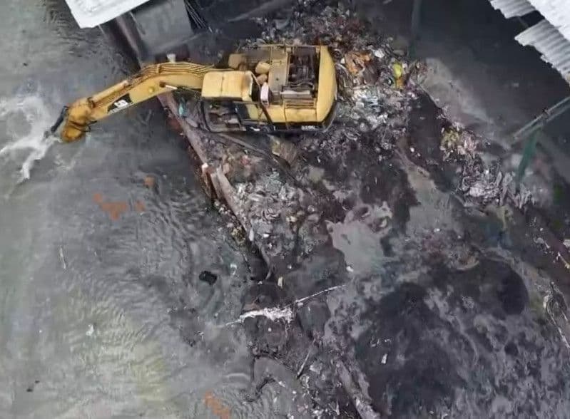 Máy xúc đang chôn lấp chất thải trái phép, minh họa cho những sai phạm đạo đức và rủi ro pháp lý mà doanh nghiệp có thể vướng phải