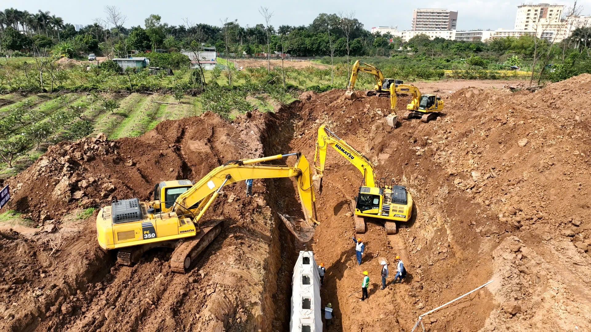Máy xúc đang thi công đào đất tại một công trường xây dựng, tượng trưng cho công tác giải phóng mặt bằng và xây dựng hạ tầng.