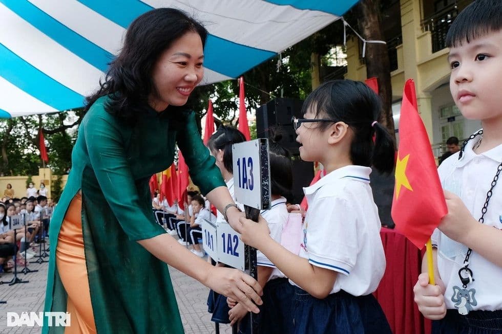 Nữ cán bộ quản lý giáo dục hoặc giáo viên tương tác với học sinh, minh họa việc chuyển đổi vai trò và tập trung vào học sinh.