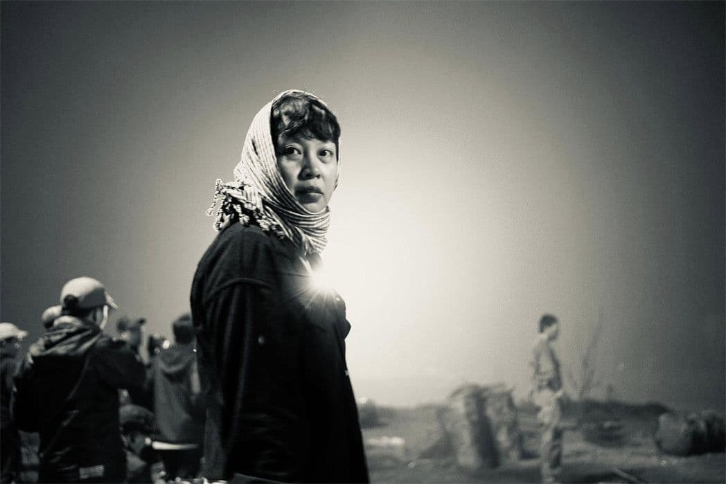 Nữ diễn viên hóa thân thành nhân vật thời chiến với khăn trùm đầu, ánh mắt sâu sắc trong phim 'Mưa Đỏ'.