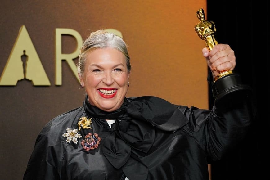 Nữ diễn viên tươi cười cầm tượng vàng Oscar 2026, biểu tượng của vinh quang điện ảnh.