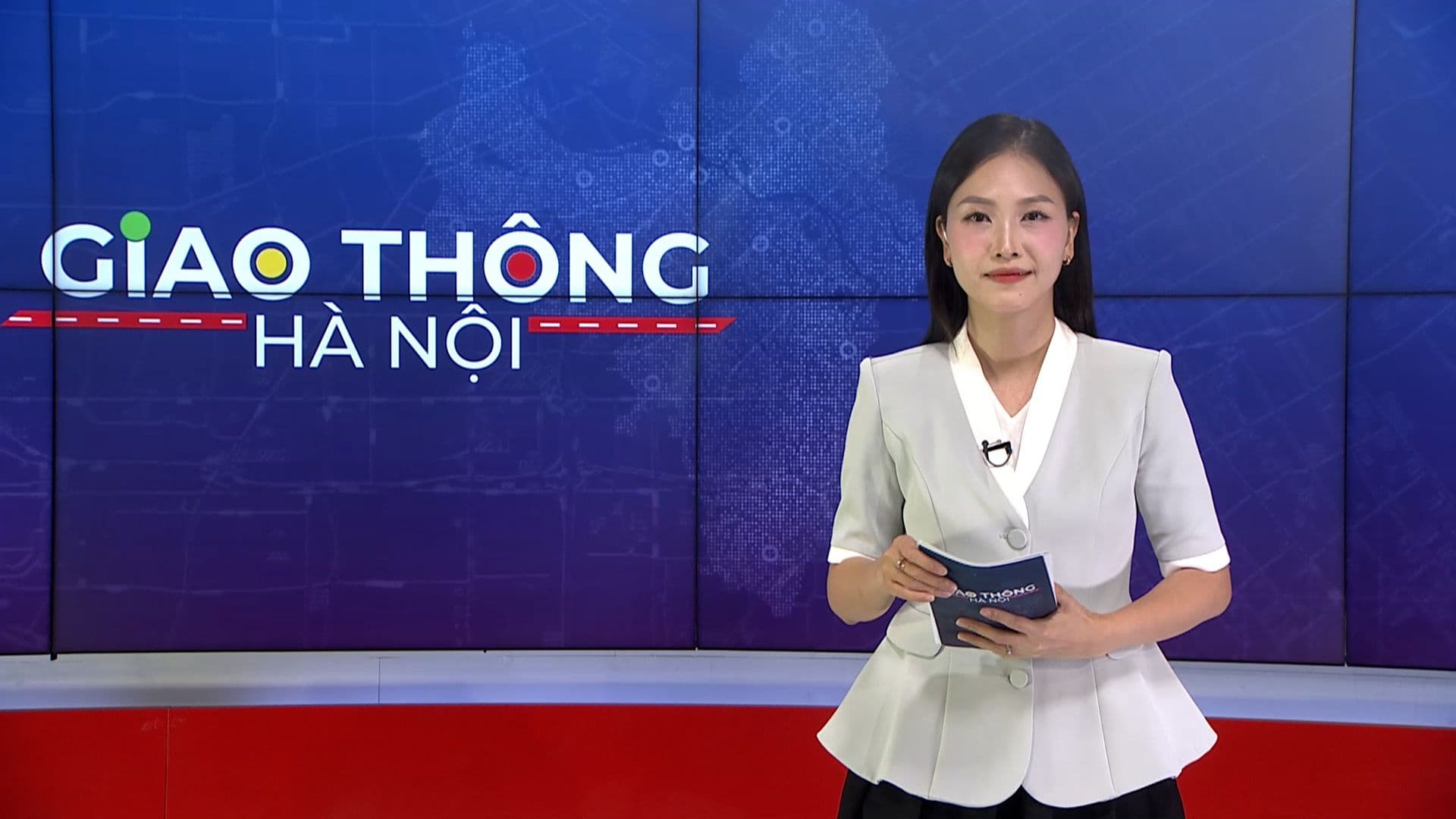 Nữ phát thanh viên trình bày tin tức giao thông Hà Nội trên nền bản đồ đô thị.