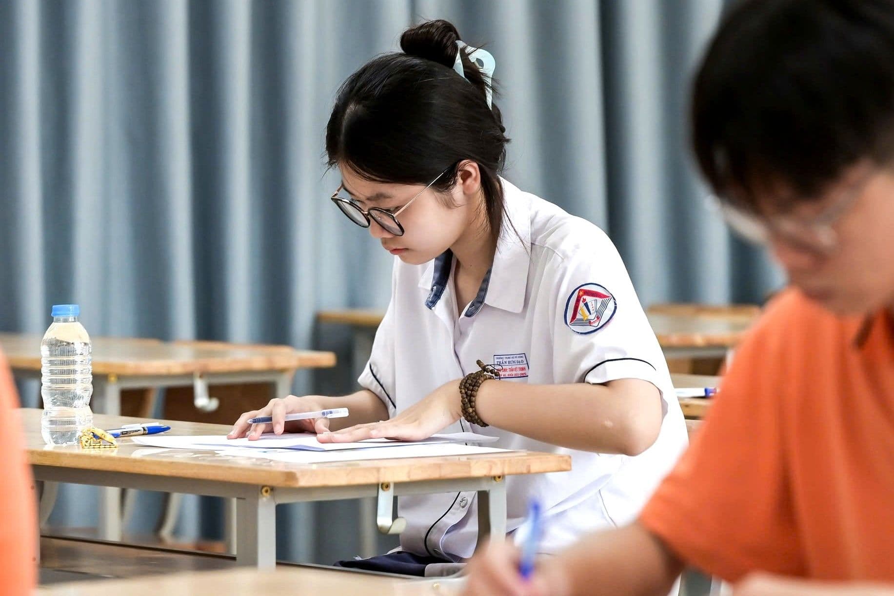 Nữ sinh tập trung làm bài thi, đối mặt với kỳ thi đại học 2025 đầy bất định.