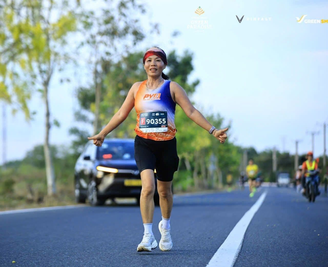 Nữ vận động viên chạy marathon trên con đường xanh mát, thể hiện tầm nhìn phát triển đô thị bền vững và lối sống hài hòa với thiên nhiên tại Cần Giờ.