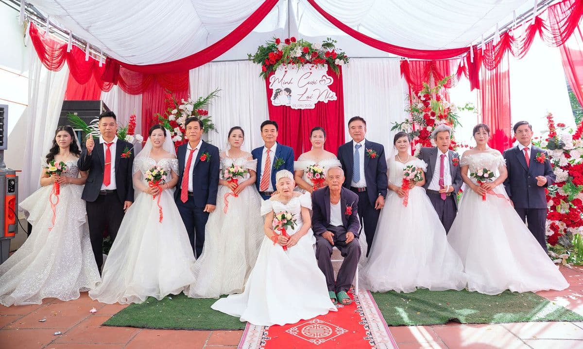 Ông bà 93 tuổi và sáu cặp đôi con cháu trong trang phục cưới, tạo dáng chụp ảnh tại hôn lễ tái hiện.
