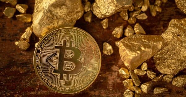 Đồng Bitcoin và vàng thô, biểu tượng cho vùng đáy lịch sử và cơ hội tích lũy vàng.