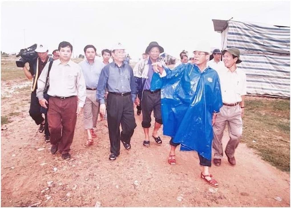 Ông Lê Huy Ngọ trong trang phục giản dị, quần xắn cao, lội qua vùng ngập lụt cùng đoàn công tác, thể hiện tinh thần "Bộ trưởng chân đất".