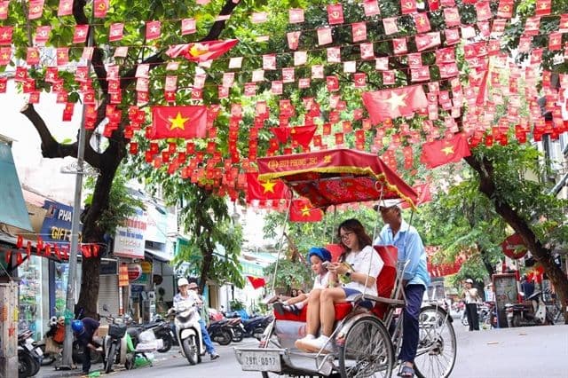 Đường phố Hà Nội được trang hoàng cờ đỏ sao vàng và cờ Đảng chuẩn bị cho đại lễ.