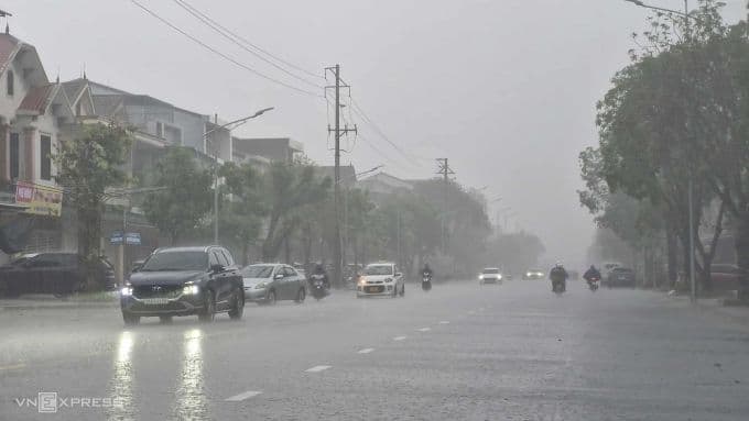 Đường phố Hà Tĩnh với xe cộ di chuyển dưới trời mưa nhẹ, thể hiện sự chuẩn bị trước áp thấp nhiệt đới.