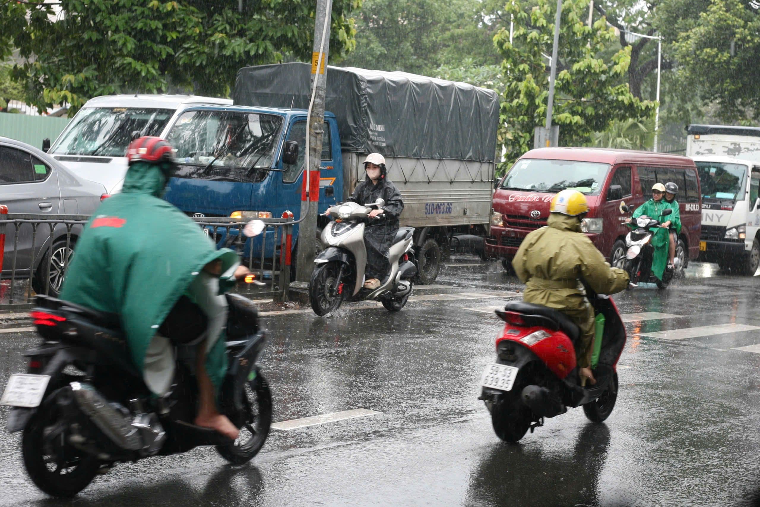 Đường phố Sài Gòn ngập sâu sau mưa lớn, người dân di chuyển khó khăn.