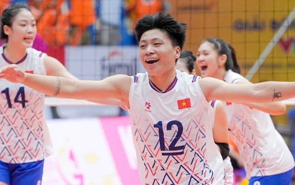 Đặng Thị Hồng (số 12) mỉm cười trên sân bóng chuyền, thể hiện tài năng và niềm đam mê của cô.