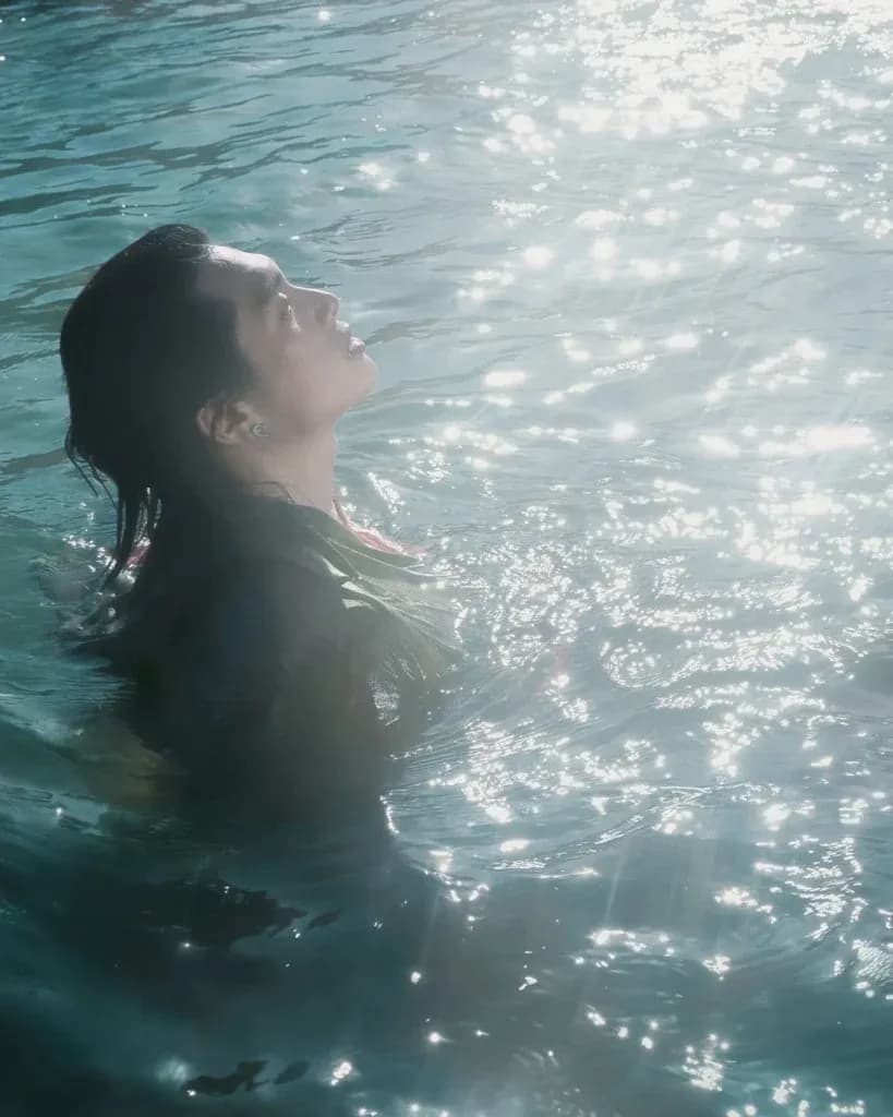 Nghệ sĩ GREY D ngâm mình trong nước, ngước nhìn ánh sáng, thể hiện áp lực vô hình và sự tìm kiếm giá trị thật trong âm nhạc.