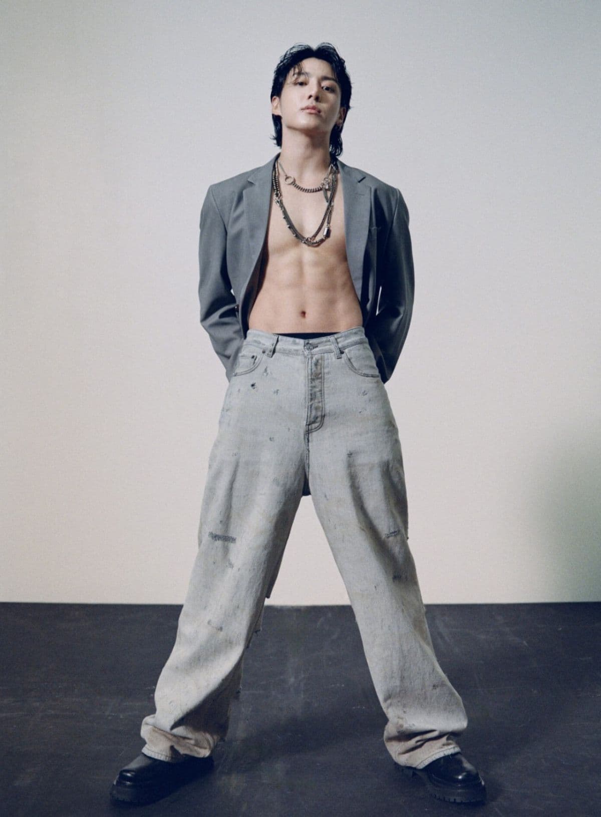 Nghệ sĩ K-Pop Jungkook trong trang phục thời trang, thể hiện sự nổi bật và thành công trên các bảng xếp hạng toàn cầu.