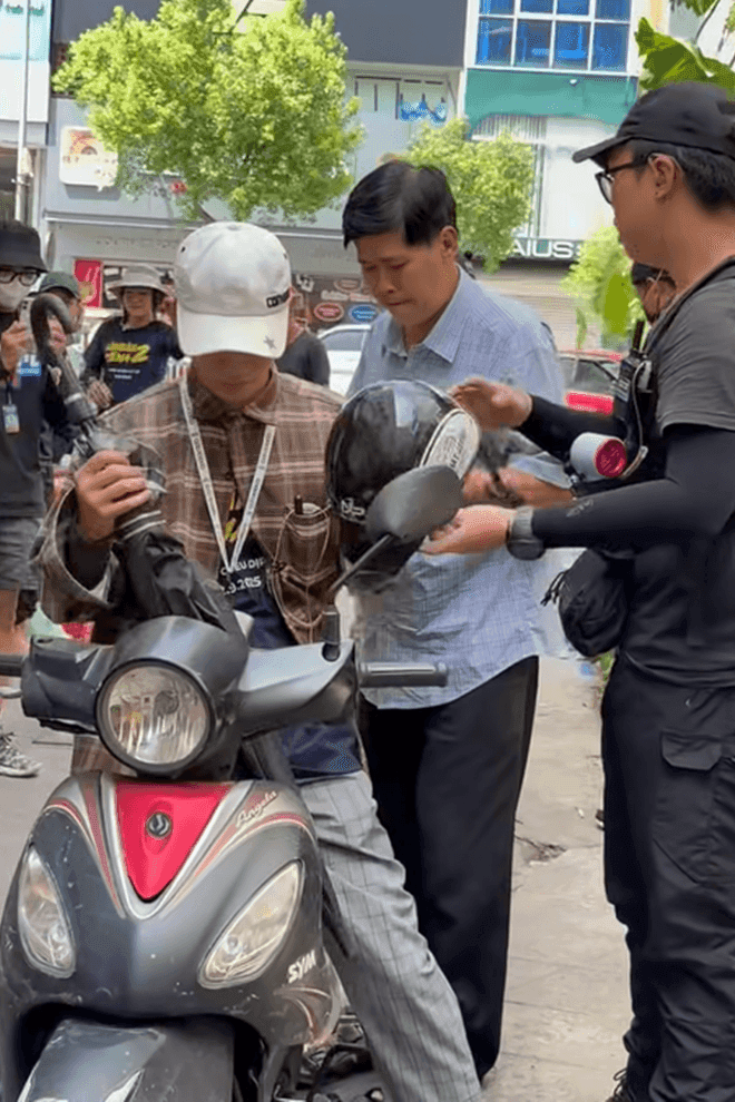 Nghệ sĩ Phước Sang được đồng nghiệp hỗ trợ đội mũ bảo hiểm và di chuyển trên xe máy, minh chứng cho tình đồng nghiệp trân quý trên phim trường.