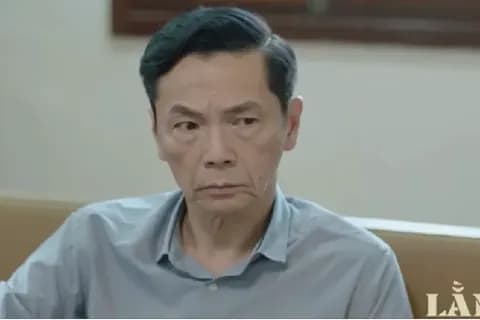 Nghiêm, người hướng dẫn cấp trên, với ánh mắt khó đoán trong phim 'Lằn ranh', đại diện cho cạm bẫy lợi dụng quyền lực nơi công sở.