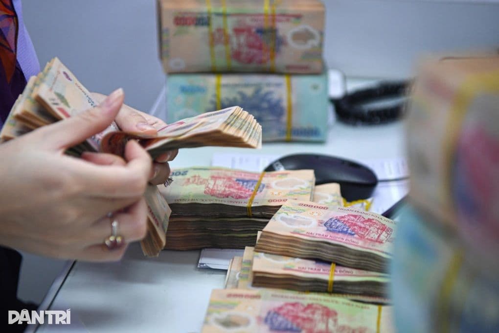 Người đang đếm tiền Việt Nam Đồng tại quầy giao dịch ngân hàng, tượng trưng cho hoạt động gửi tiền và lãi suất