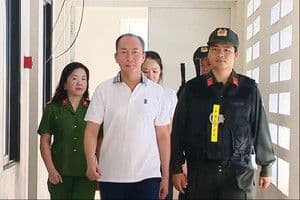 Người bị cảnh sát dẫn giải, thể hiện quá trình tố tụng và trách nhiệm của hệ thống pháp luật.