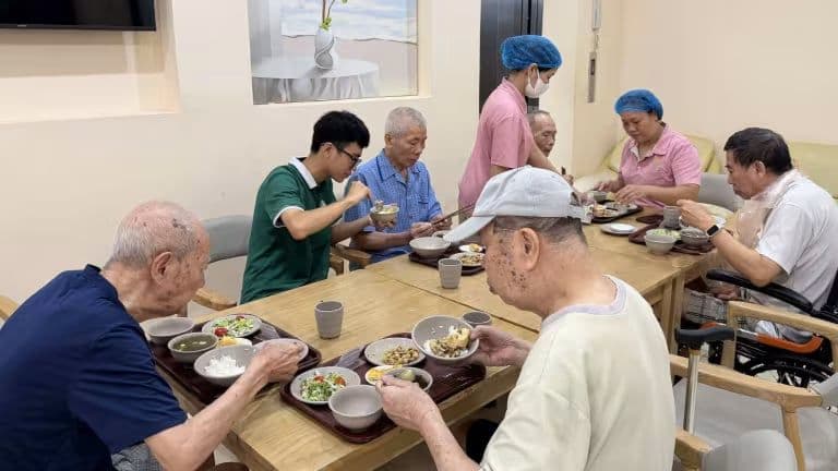 Người cao tuổi dùng bữa trong môi trường được chăm sóc, đặt ra câu hỏi về việc chuyển đổi từ chăm sóc nghĩa vụ sang hỗ trợ giá trị.