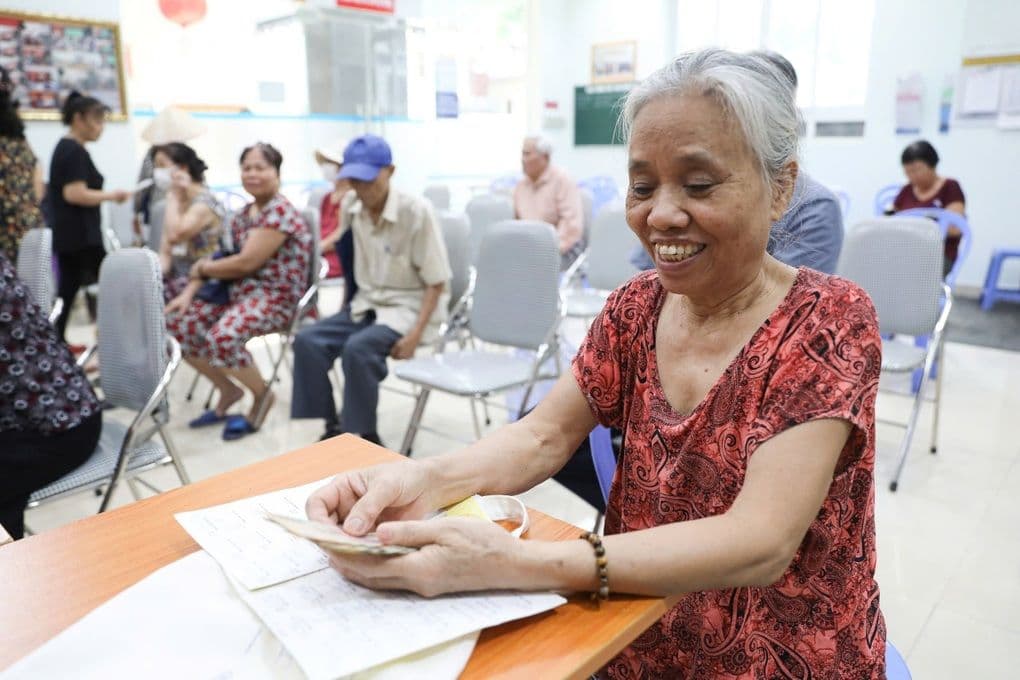 Người cao tuổi nhận lương hưu, thể hiện chính sách an sinh xã hội và sự quan tâm của nhà nước.