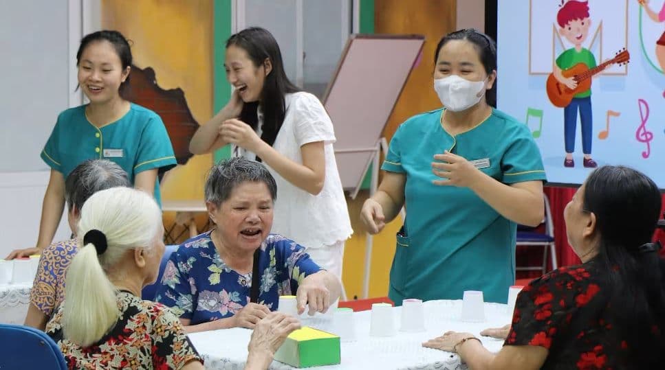 Người cao tuổi tham gia hoạt động vui chơi cùng nhân viên chăm sóc, thể hiện tiềm năng của kinh tế bạc.