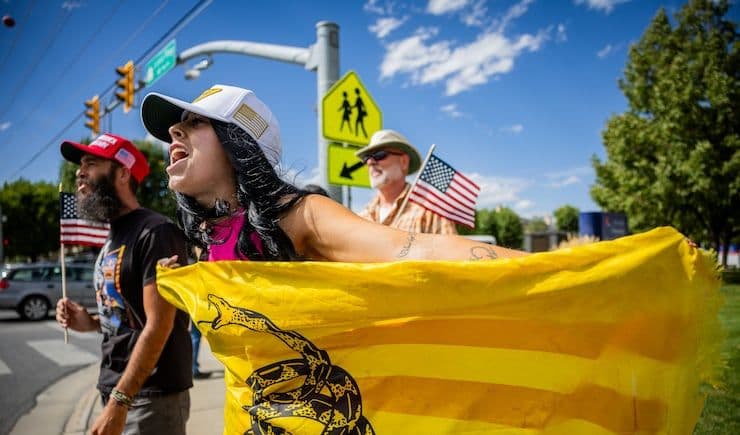 Người dân biểu tình trên đường phố với cờ Mỹ và cờ Gadsden, thể hiện sự phân cực chính trị sau vụ ám sát.