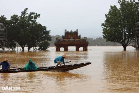 Người dân chèo thuyền trên dòng nước lũ cao ngập cổng thành cổ ở Huế, miền Trung Việt Nam.