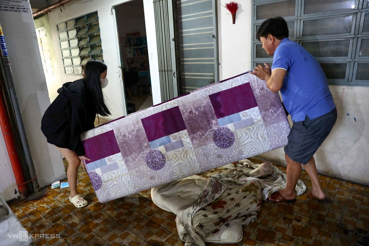 Người dân di chuyển đồ đạc sau vụ hỏa hoạn, thể hiện sự nỗ lực của cộng đồng trong việc khắc phục hậu quả