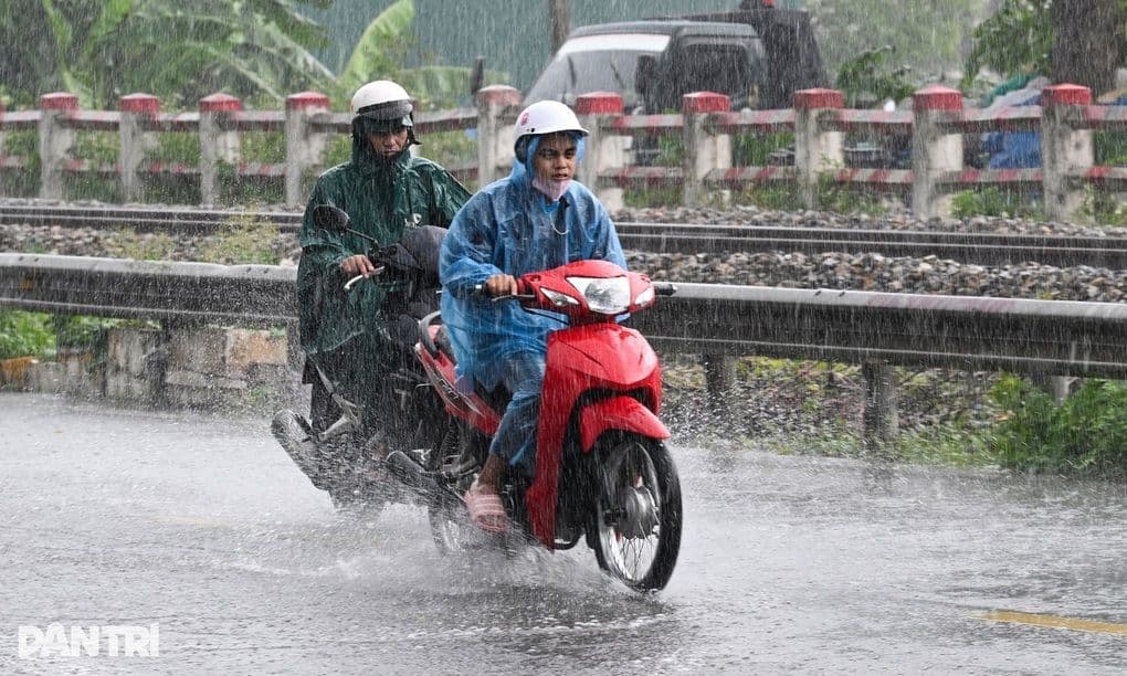 Người dân di chuyển dưới mưa lớn, minh họa tác động của thời tiết cực đoan và vai trò của dự báo khí tượng thủy văn