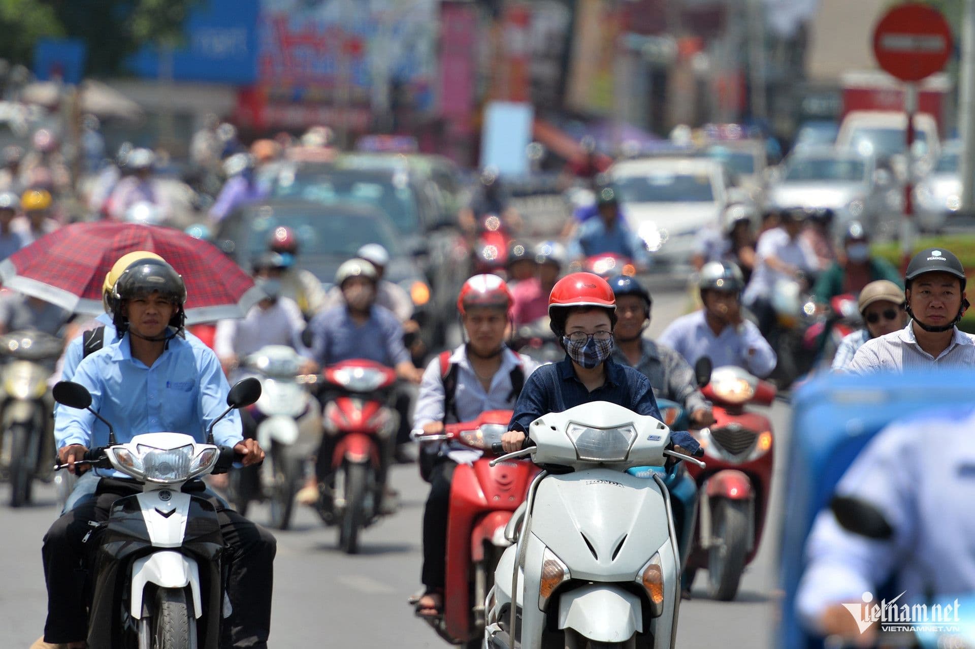 Người dân di chuyển dưới nắng nóng gay gắt trên đường phố đô thị, thể hiện tác động của đợt nắng nóng kỷ lục