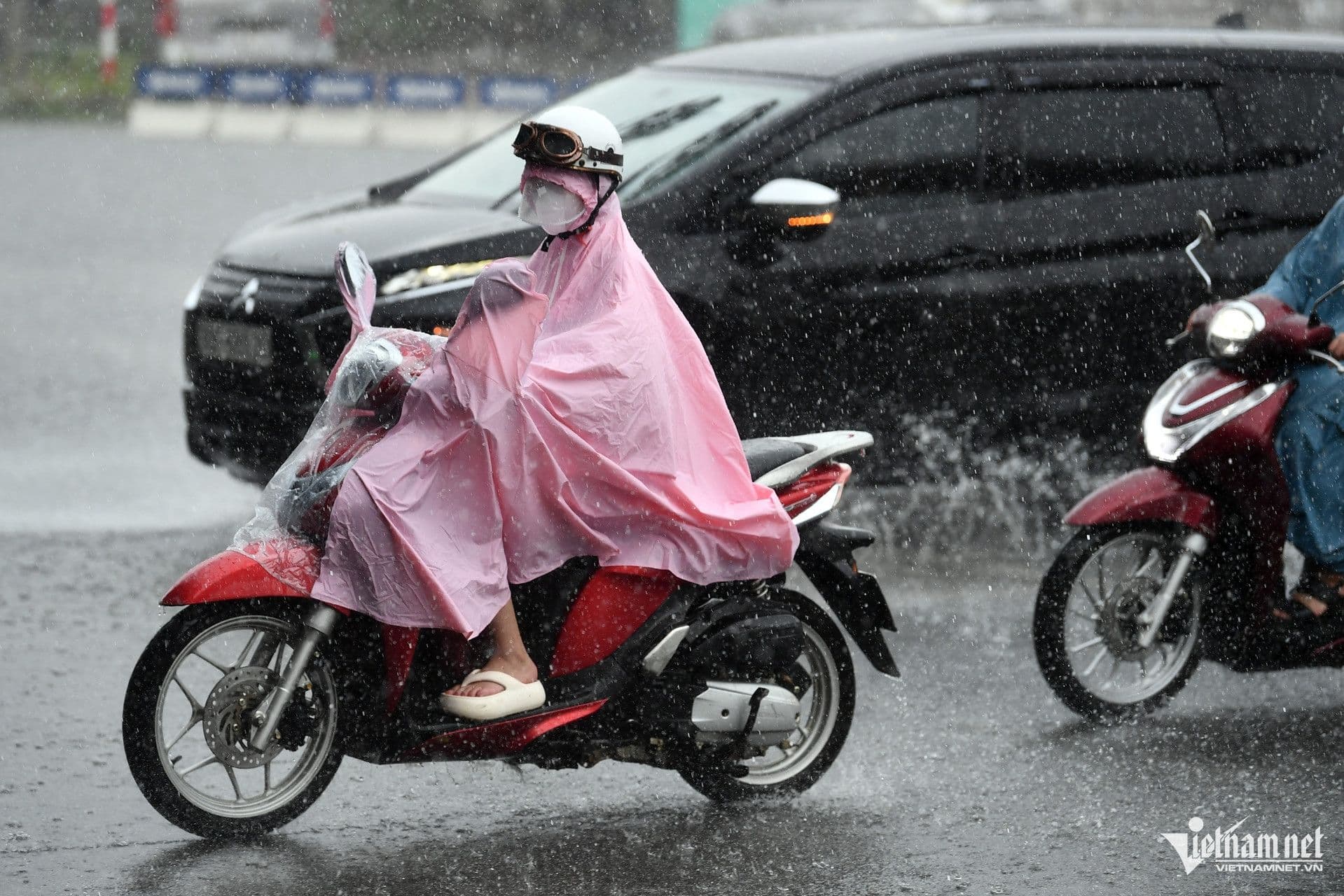 Người dân di chuyển trên đường ngập nước trong cơn mưa lớn ở đô thị Việt Nam.