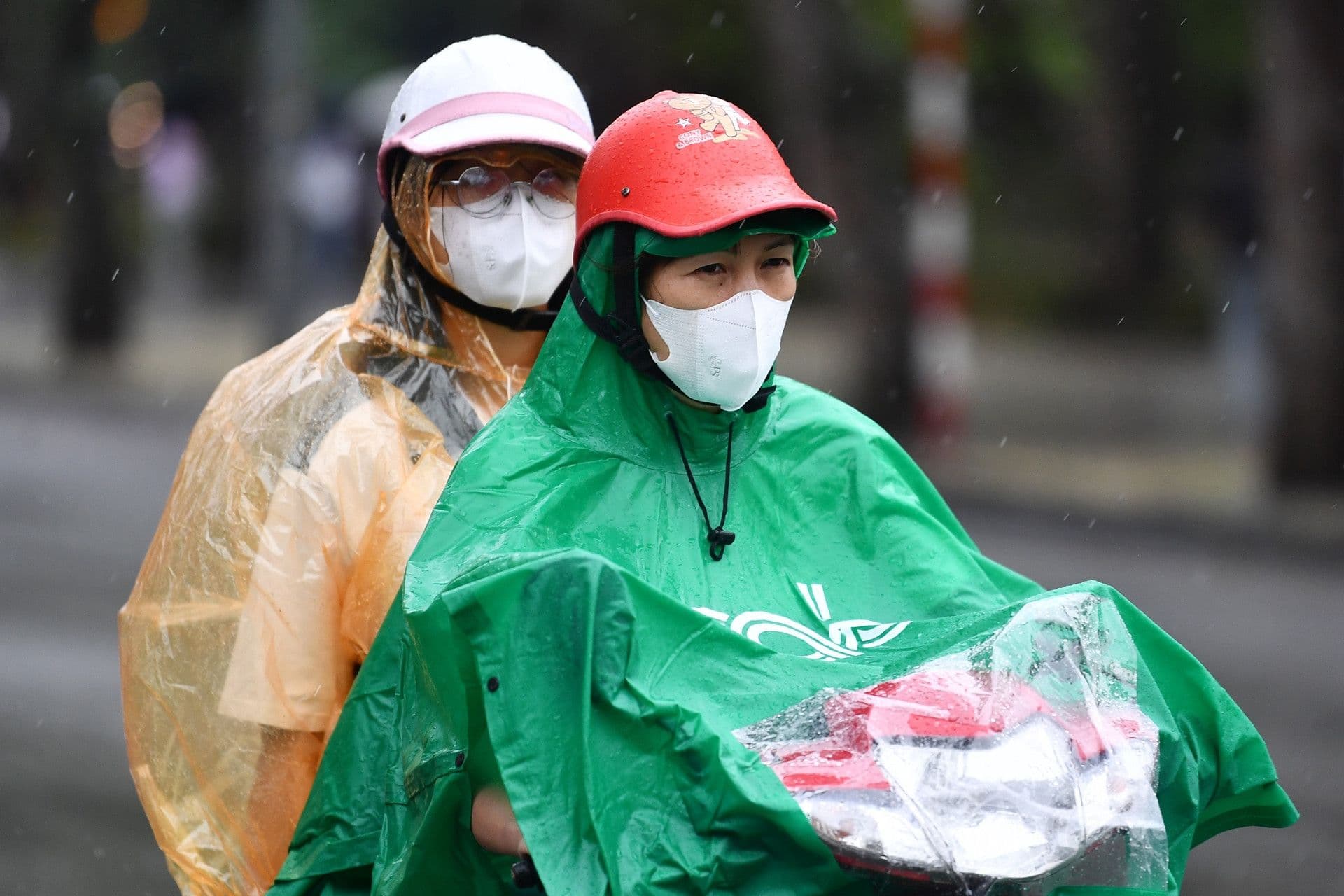 Người dân di chuyển trong mưa lớn, thể hiện sự biến động từ nắng nóng sang dông lốc.